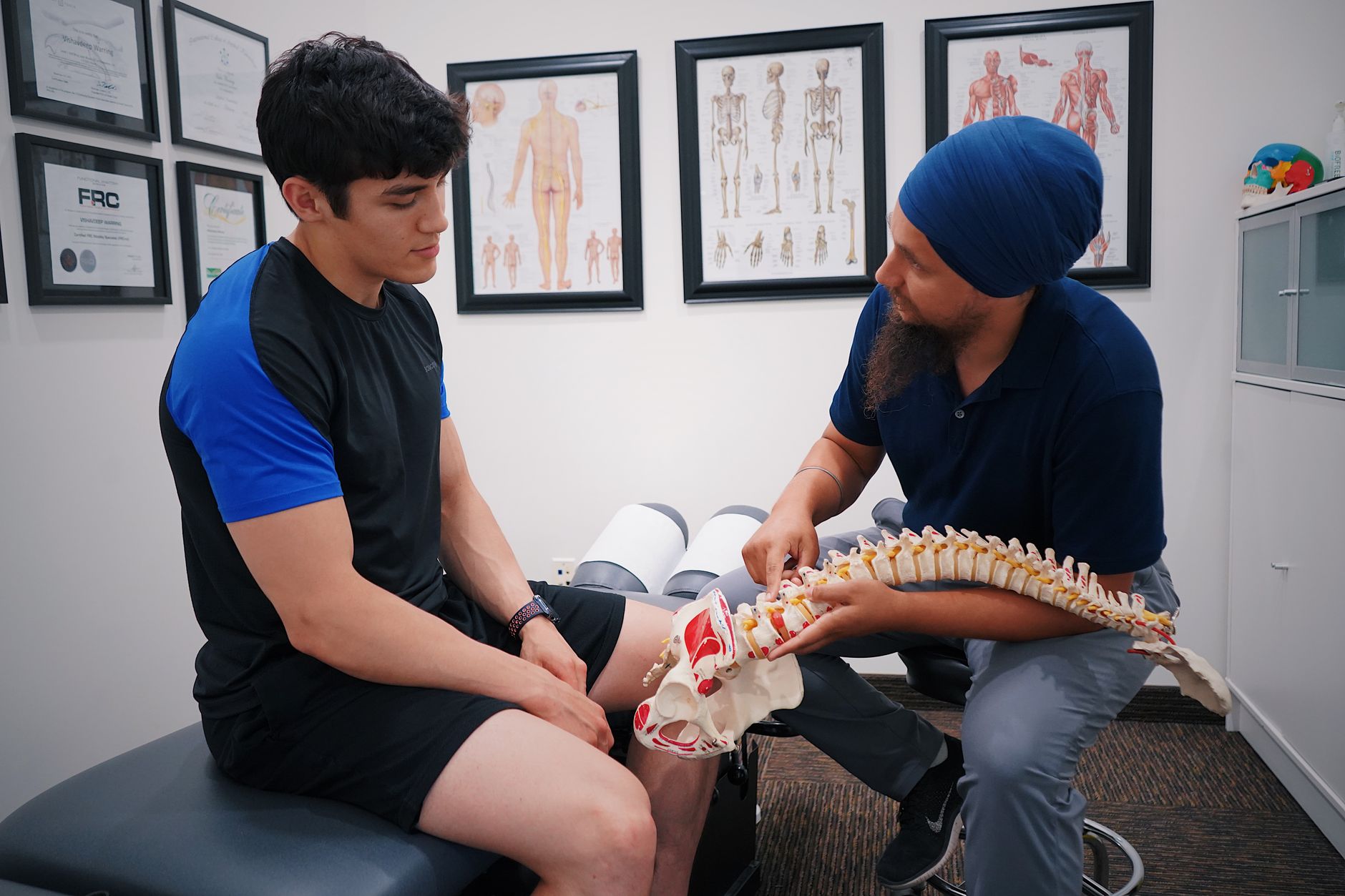 Doctor explaining spinal health to a patient using a spine model