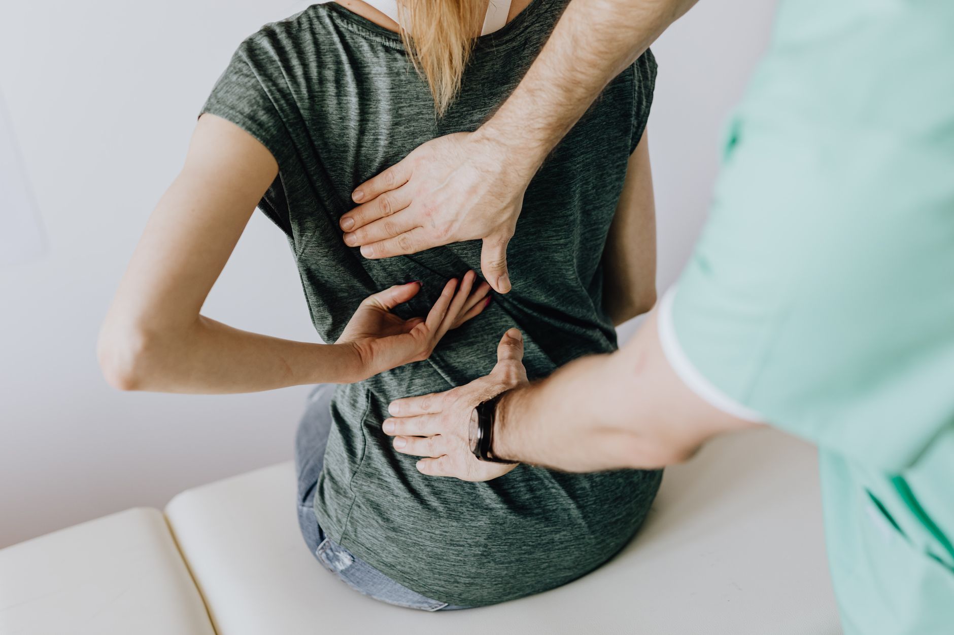 Patient indicating a painful spot on her back during a chiropractic assessment
